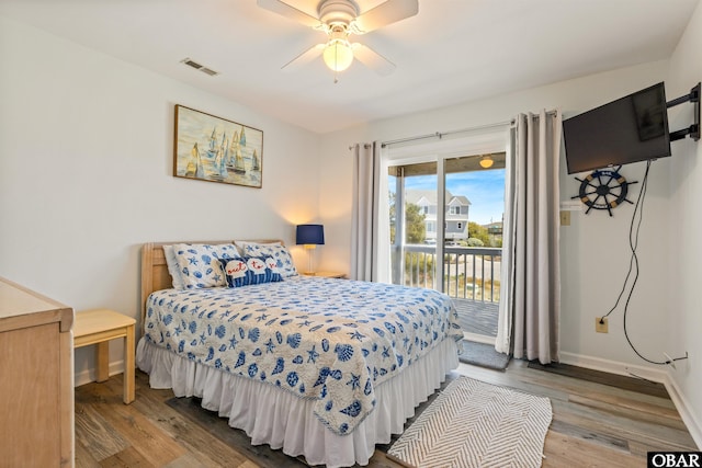 bedroom with ceiling fan, wood finished floors, visible vents, baseboards, and access to outside