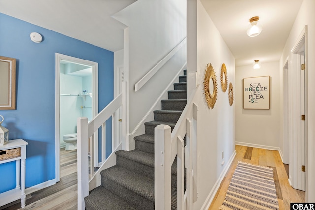 stairs featuring wood finished floors and baseboards