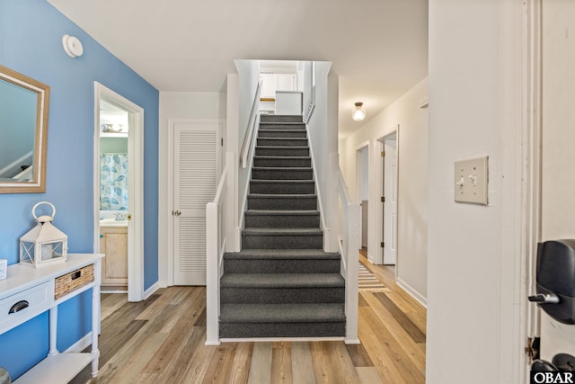 staircase featuring wood finished floors and baseboards