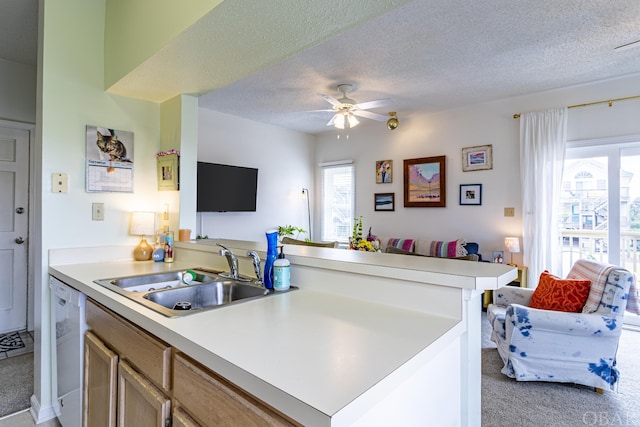 kitchen with light colored carpet, light countertops, a sink, and a peninsula