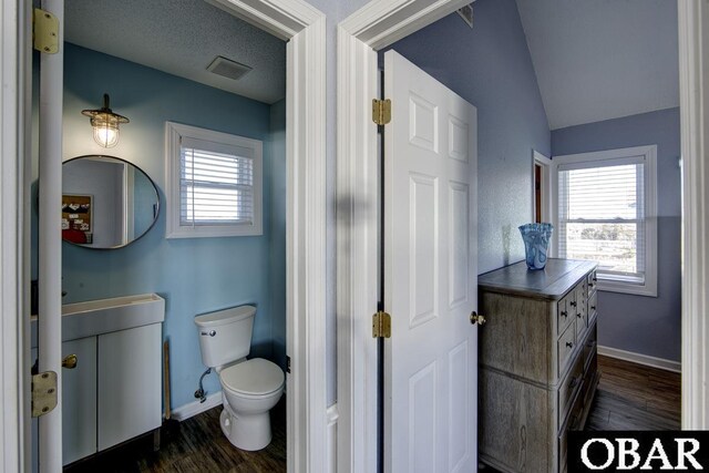24255 S Shore Dr Lot # 9, Rodanthe, NC 27968 - bathroom featuring vanity, wood finished floors, toilet, plenty of natural light, and lofted ceiling