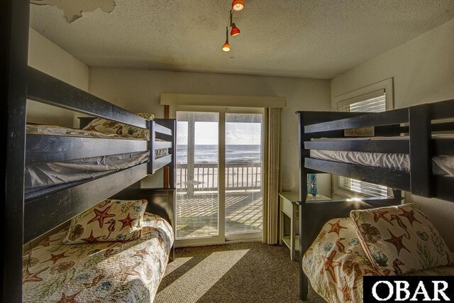 24255 S Shore Dr Lot # 9, Rodanthe, NC 27968 - bedroom with access to exterior, carpet, a textured ceiling, and a water view