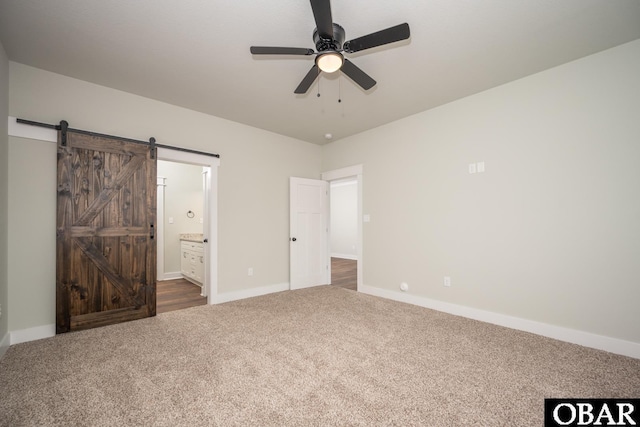 329 Country Club Rd Lot A, Lot A, Camden, NC 27921 - unfurnished bedroom featuring dark colored carpet, baseboards, ensuite bathroom, a barn door, and ceiling fan