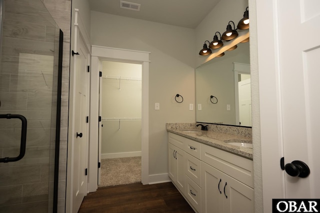 329 Country Club Rd Lot A, Lot A, Camden, NC 27921 - bathroom with wood finished floors, double vanity, a shower stall, a walk in closet, and baseboards