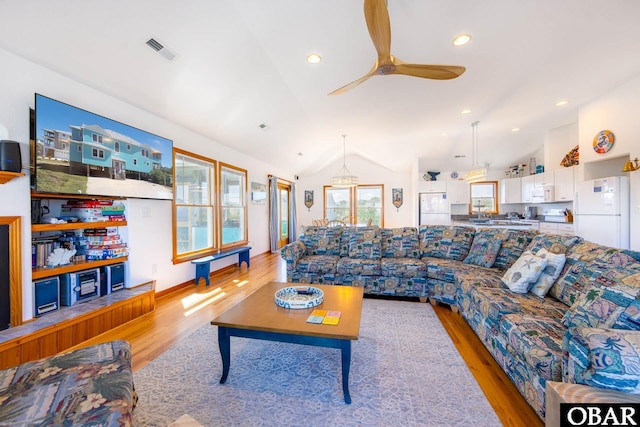 living area with lofted ceiling, light wood-type flooring, visible vents, and a ceiling fan