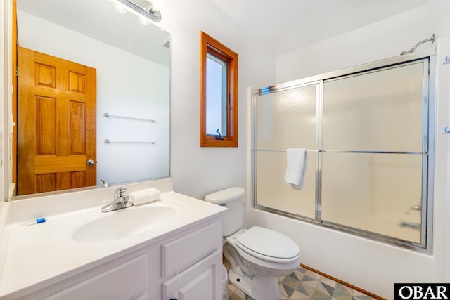 bathroom with toilet, bath / shower combo with glass door, and vanity