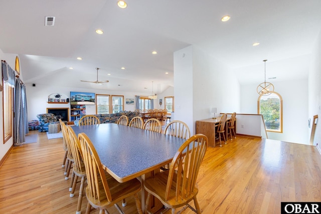 dining space with lofted ceiling, recessed lighting, a fireplace, visible vents, and light wood-style floors