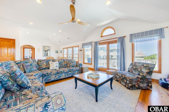 living room featuring arched walkways, light wood finished floors, lofted ceiling, recessed lighting, and a ceiling fan