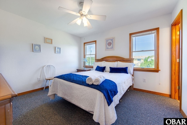 bedroom with baseboards, dark carpet, and a ceiling fan