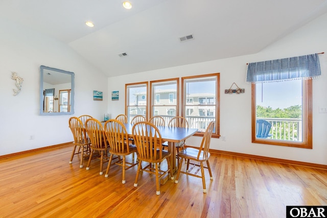 dining room with lofted ceiling, light wood-style flooring, and visible vents