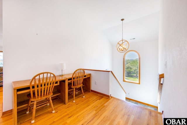 dining area with lofted ceiling, light wood finished floors, baseboards, and an inviting chandelier