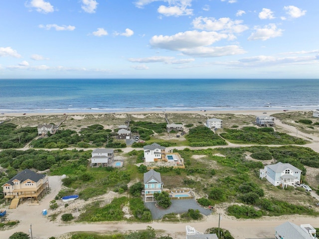 drone / aerial view featuring a water view and a view of the beach