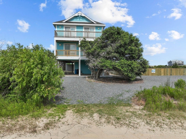 beach home featuring a carport, a balcony, and driveway