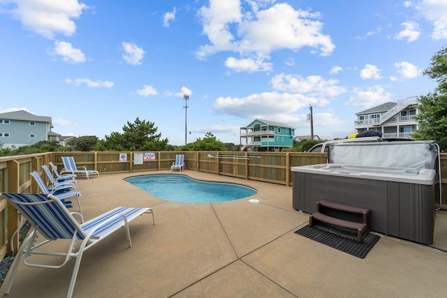 view of swimming pool featuring a patio, a fenced in pool, fence, and a hot tub