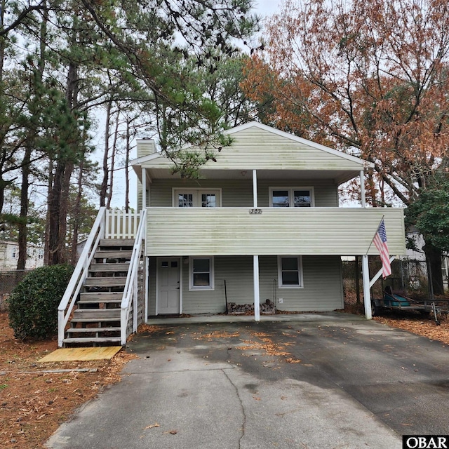 view of front of home with stairs, aphalt driveway, and a chimney