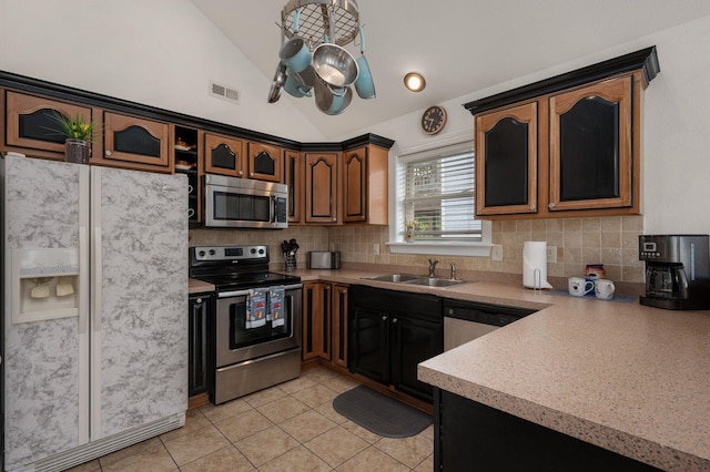 kitchen featuring a sink, visible vents, vaulted ceiling, light countertops, and appliances with stainless steel finishes