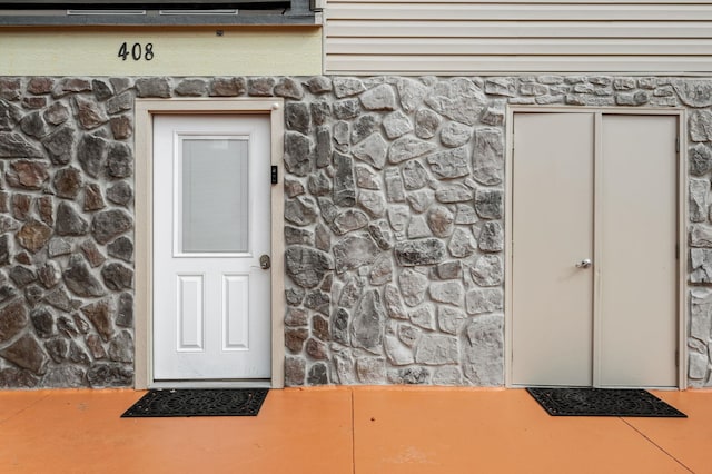 entrance to property featuring stone siding