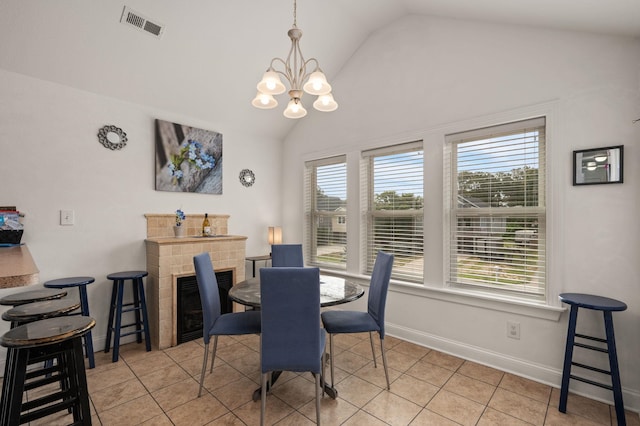 dining area featuring lofted ceiling, light tile patterned floors, visible vents, baseboards, and an inviting chandelier