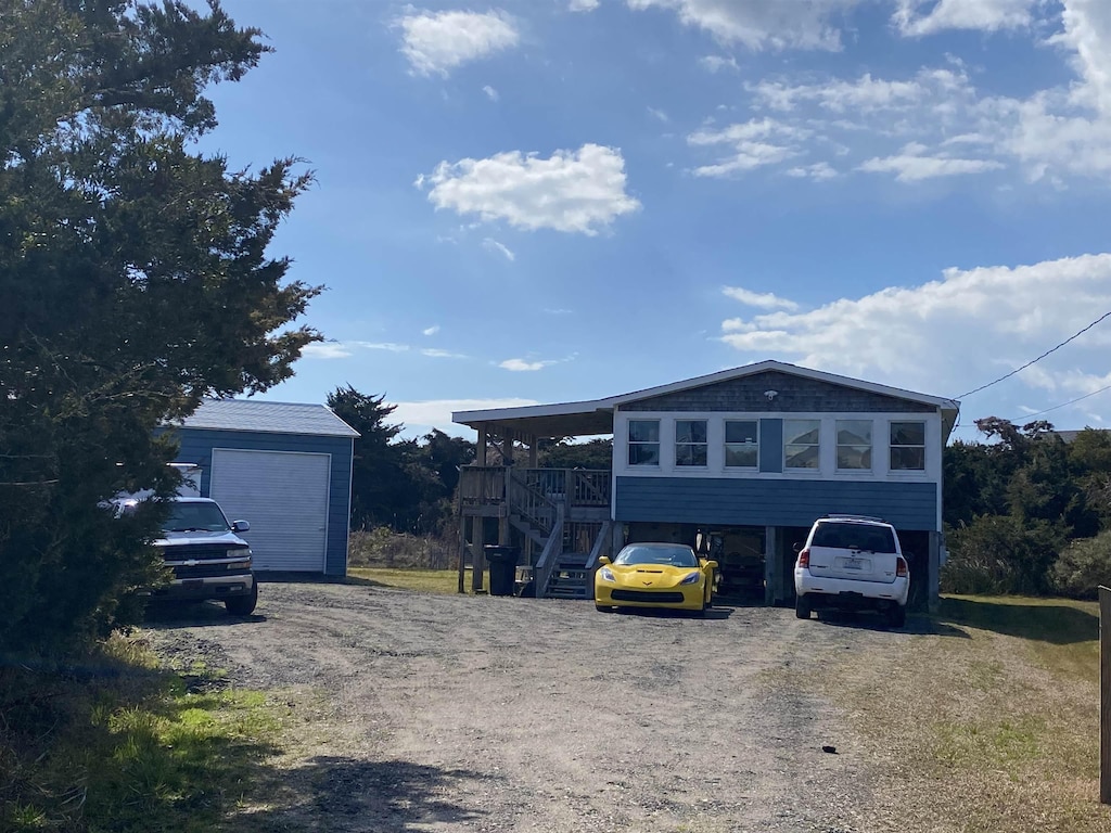 view of front of house featuring a carport, stairway, and an outdoor structure