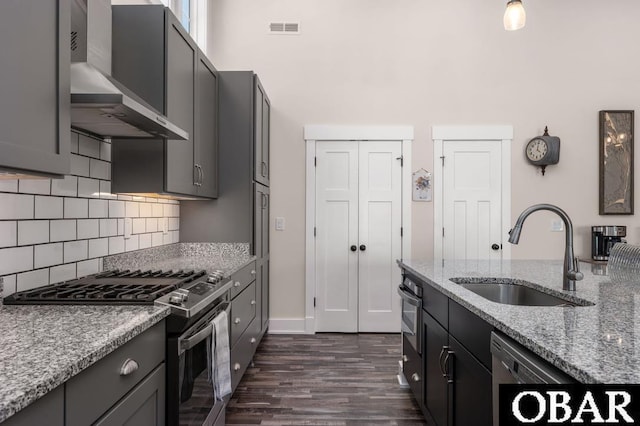 1303 W First St Lot 63, Kill Devil Hills, NC 27948 - kitchen with appliances with stainless steel finishes, a sink, wall chimney range hood, dark wood-type flooring, and light stone countertops