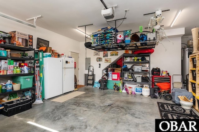 1303 W First St Lot 63, Kill Devil Hills, NC 27948 - garage featuring freestanding refrigerator, electric panel, a garage door opener, and water heater