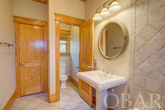 full bath featuring baseboards, toilet, and tile patterned floors