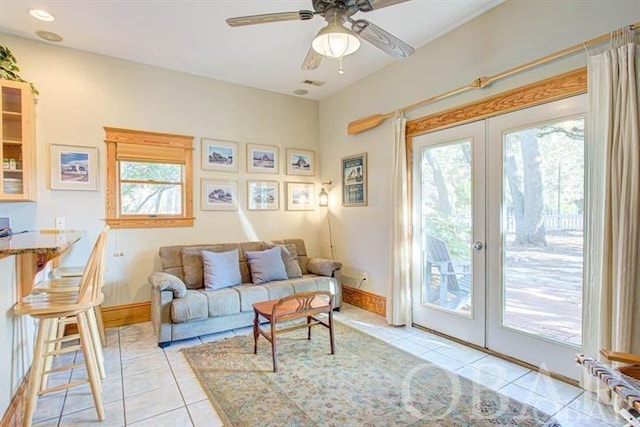 sitting room featuring french doors, a healthy amount of sunlight, baseboards, and light tile patterned floors