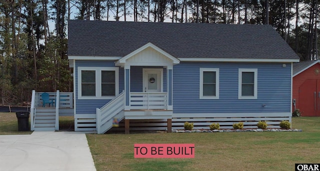 view of front of property with a porch, a front yard, roof with shingles, and stairway