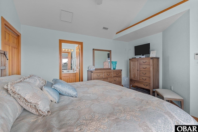 bedroom featuring visible vents, connected bathroom, and vaulted ceiling