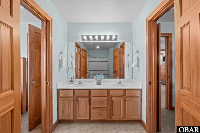 bathroom with a sink, baseboards, and double vanity