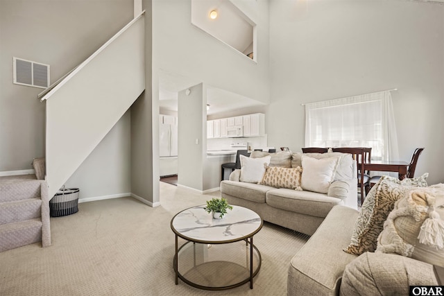 614-B Sea Oats Ct Lot # 6, Corolla, NC 27927 - living area with stairway, light colored carpet, and a towering ceiling
