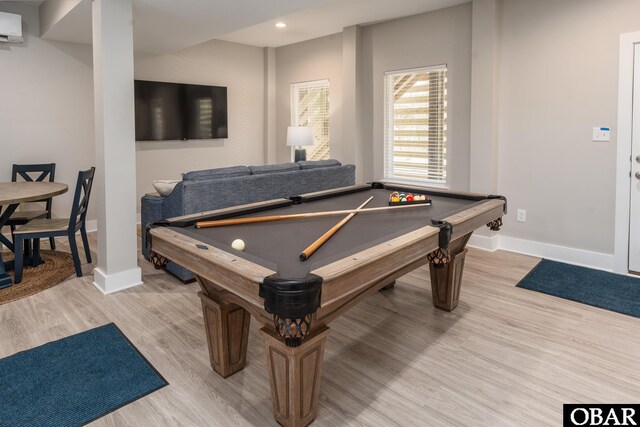 rec room with recessed lighting, baseboards, a wall unit AC, and light wood finished floors