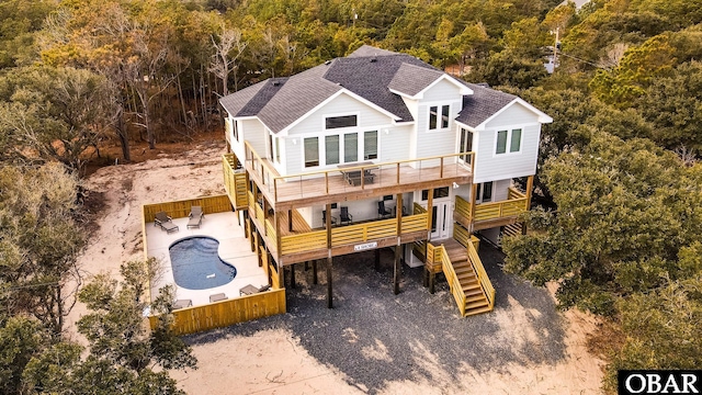 view of play area featuring a deck, stairway, and fence