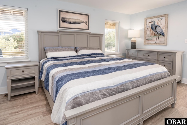 bedroom with light wood-type flooring and baseboards