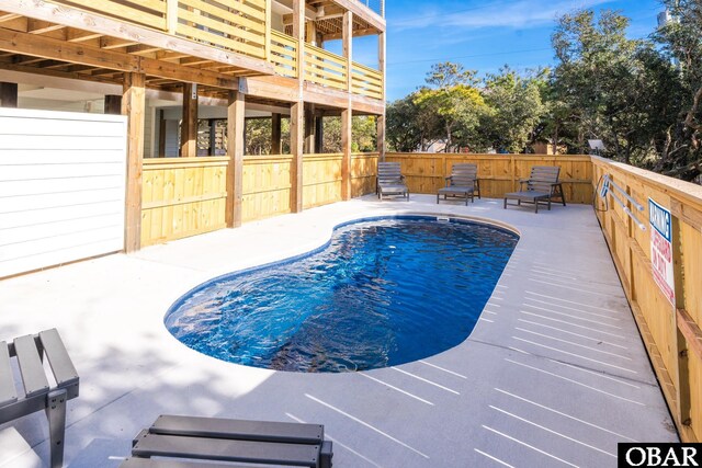 view of swimming pool featuring fence, a fenced in pool, and a patio