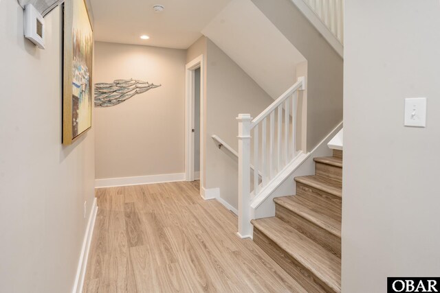 stairs with recessed lighting, wood finished floors, and baseboards