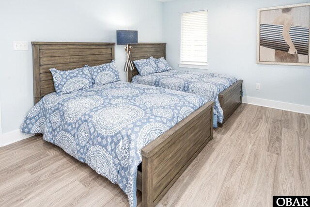 bedroom with light wood-type flooring and baseboards