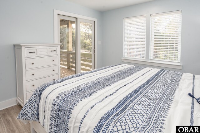 bedroom featuring baseboards, access to outside, and light wood-style floors