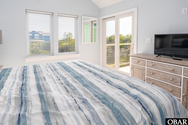 bedroom with access to outside, multiple windows, and vaulted ceiling