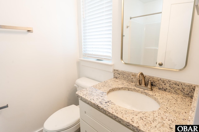 full bath featuring walk in shower, vanity, and toilet