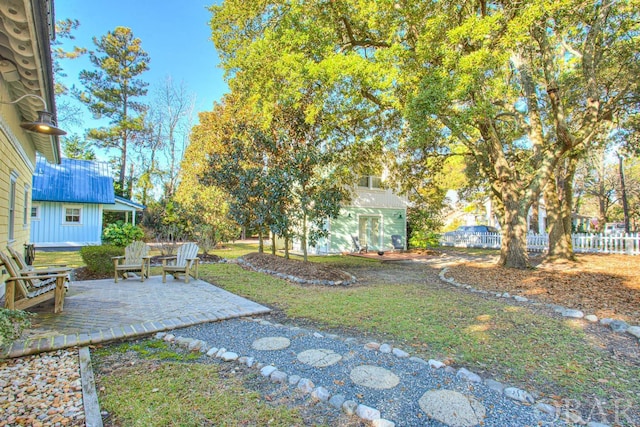 view of yard with an outbuilding, a patio, and fence