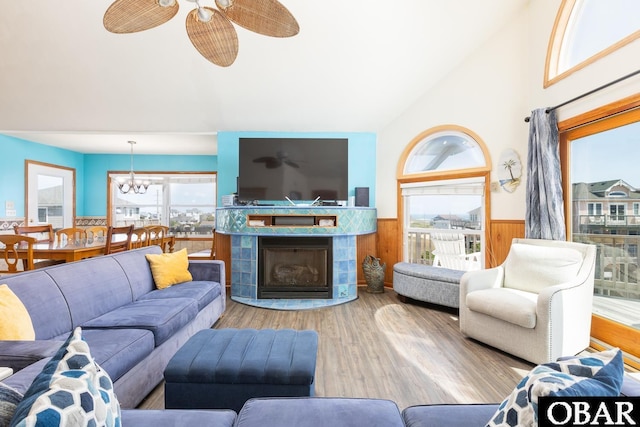 23212 Sea Oats Dr Lot 18, Rodanthe, NC 27968 - living area featuring a tiled fireplace, wainscoting, wood finished floors, ceiling fan with notable chandelier, and wooden walls