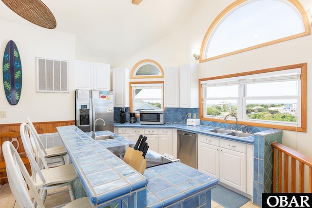 23212 Sea Oats Dr Lot 18, Rodanthe, NC 27968 - kitchen featuring white cabinets, appliances with stainless steel finishes, a sink, tile counters, and visible vents