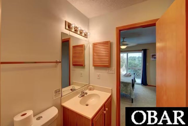 bathroom featuring vanity, toilet, and a textured ceiling