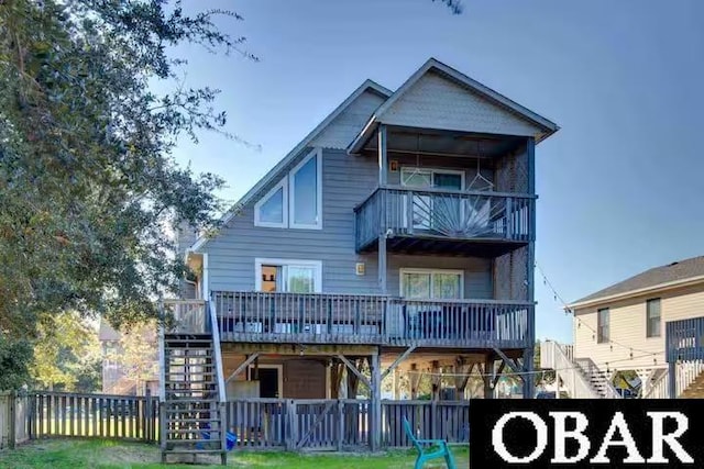 rear view of property featuring stairs, a deck, fence, and a balcony