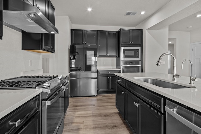 104 Garland St Lot 3, Moyock, NC 27958 - kitchen featuring a sink, under cabinet range hood, dark cabinetry, and stainless steel appliances