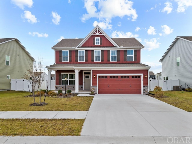 craftsman inspired home featuring an attached garage, driveway, a porch, and a front yard