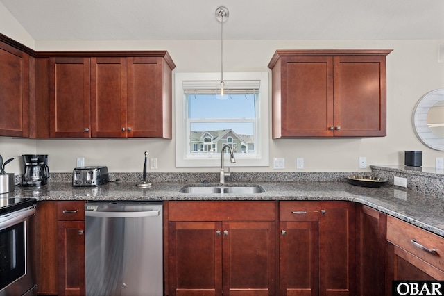 kitchen featuring stainless steel appliances, dark stone counters, decorative light fixtures, and a sink