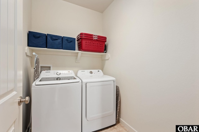 laundry area with laundry area, washing machine and dryer, and baseboards