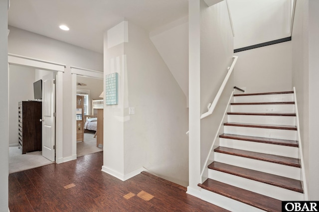 staircase featuring baseboards, wood finished floors, and recessed lighting